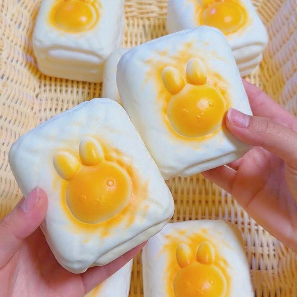 Bunny Toast Slow-Rising Squishy – Creamy White Rounded Block with a Raised Golden Rabbit Face and Side Grooves