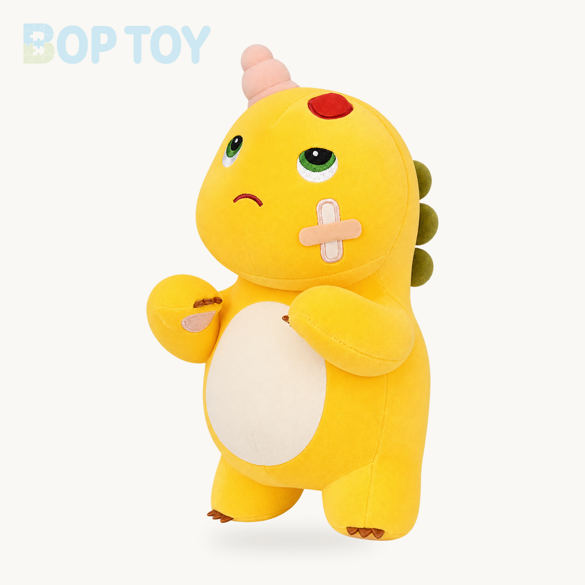 Bandaged yellow dinosaur plush, three-quarter view