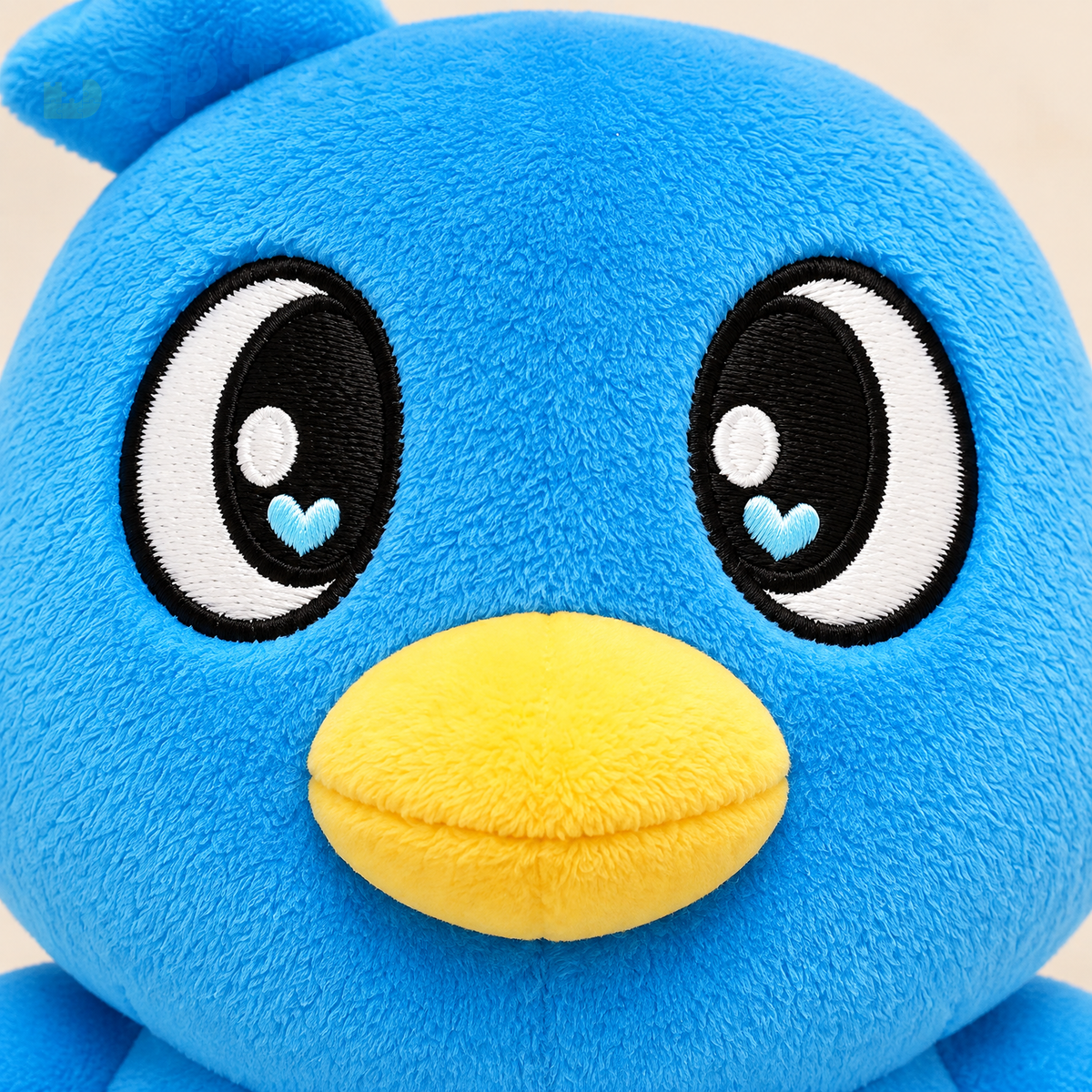Close view of blue penguin plush embroidery and soft fabric