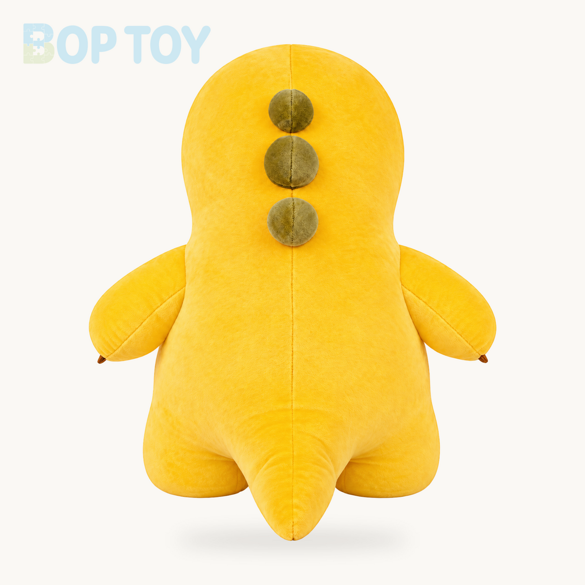 Yellow dinosaur plush toy, rear view showing tail and three back spikes
