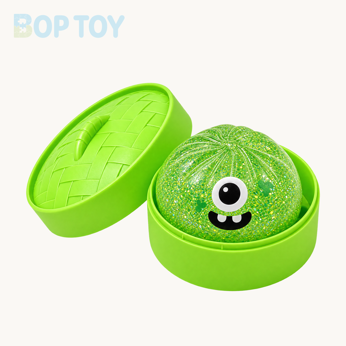 Green one-eyed monster glitter bun squishy with two teeth and matching green steamer and lid