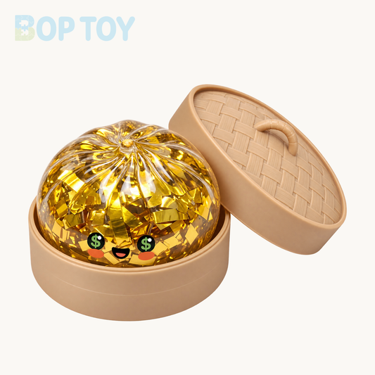 One clear gold-foil money-face bun squishy with green dollar-sign eyes and orange cheeks, in a tan steamer with matching lid