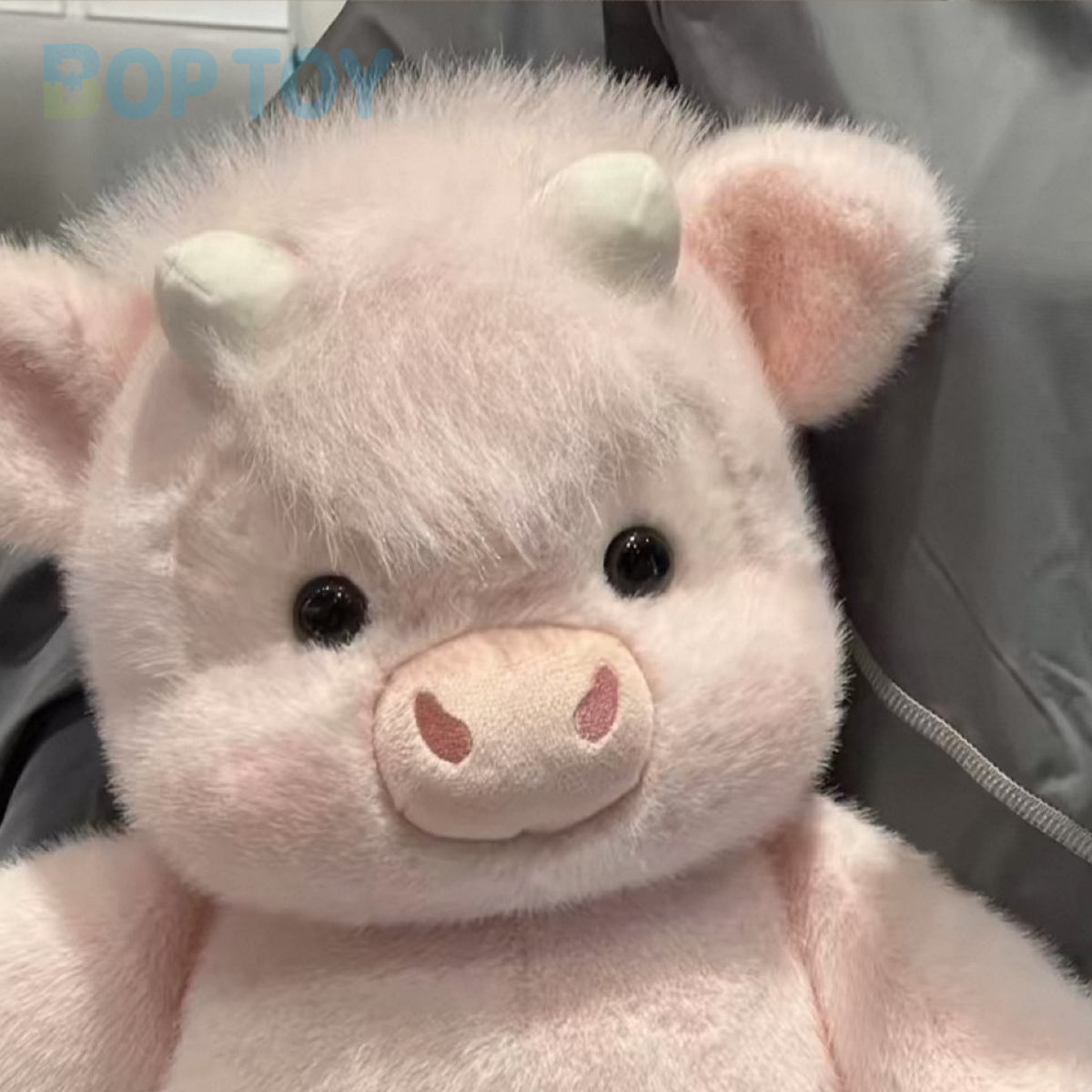 Close-up of the powder pink calf plush face, short horns and fluffy fringe